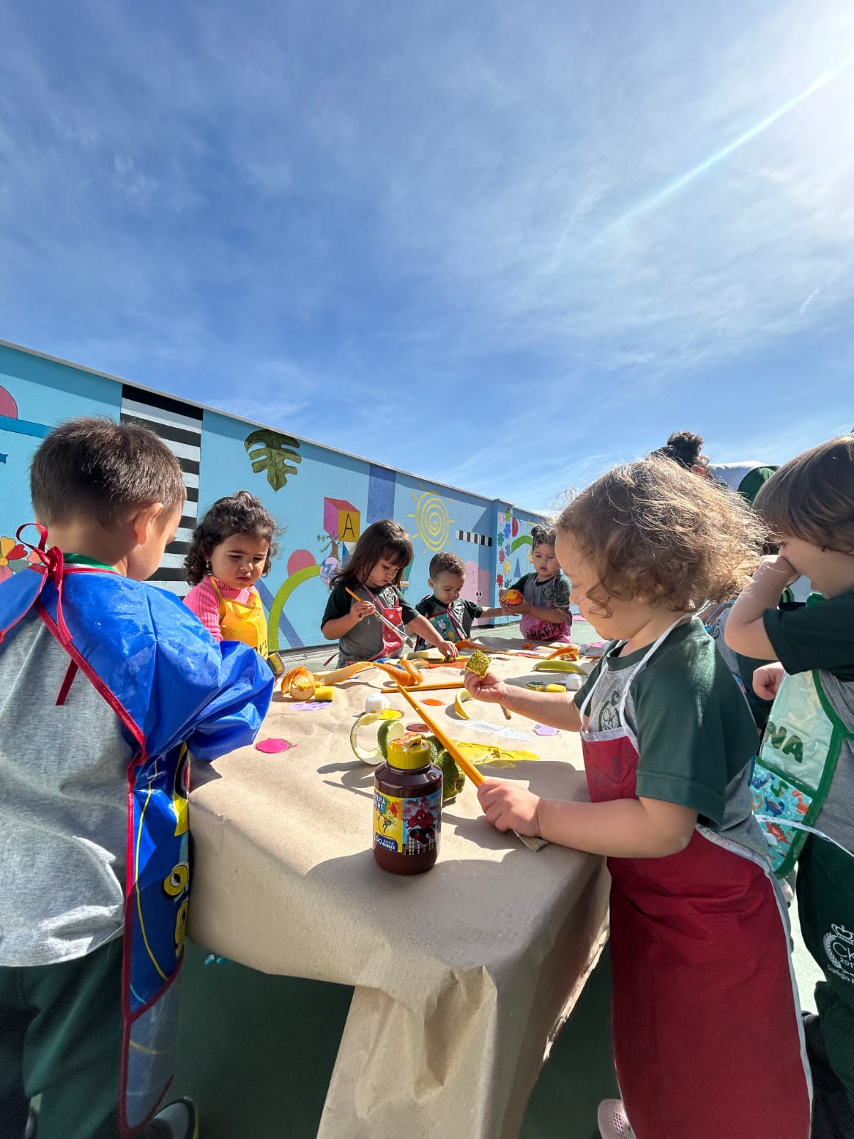 Crianças da Educação Infantil em atividade artística no espaço externo do colégio